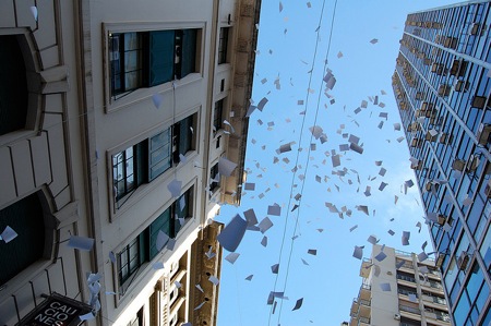 Photo of paper falling from tall office buildings.